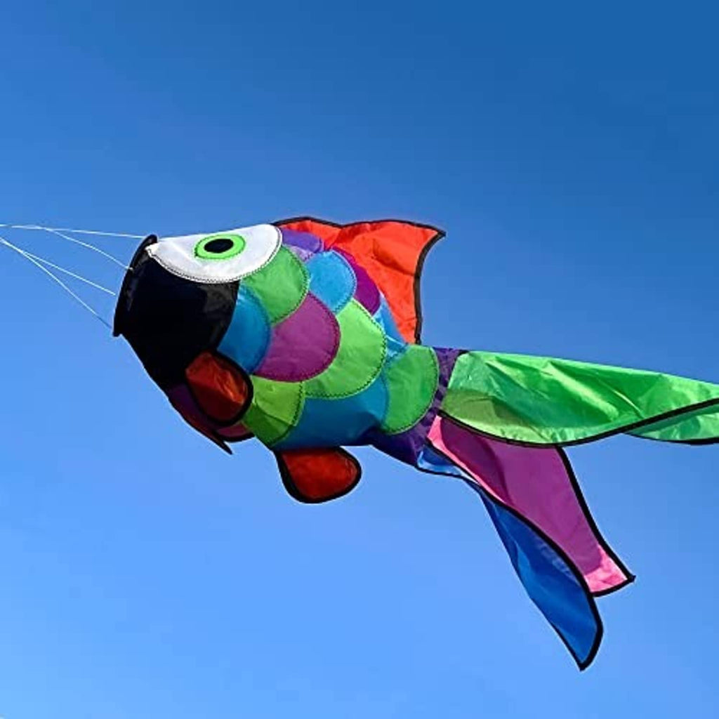Rainbow fish windsock with green eye and bright green-and-blue tail fins against the sky