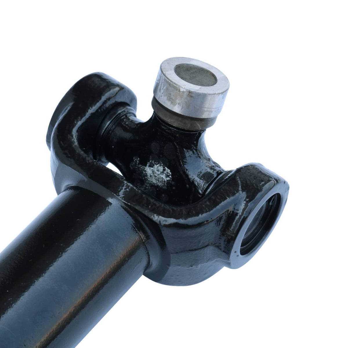 Close-up of front drive shaft U-joint housing with silver bearing caps, black