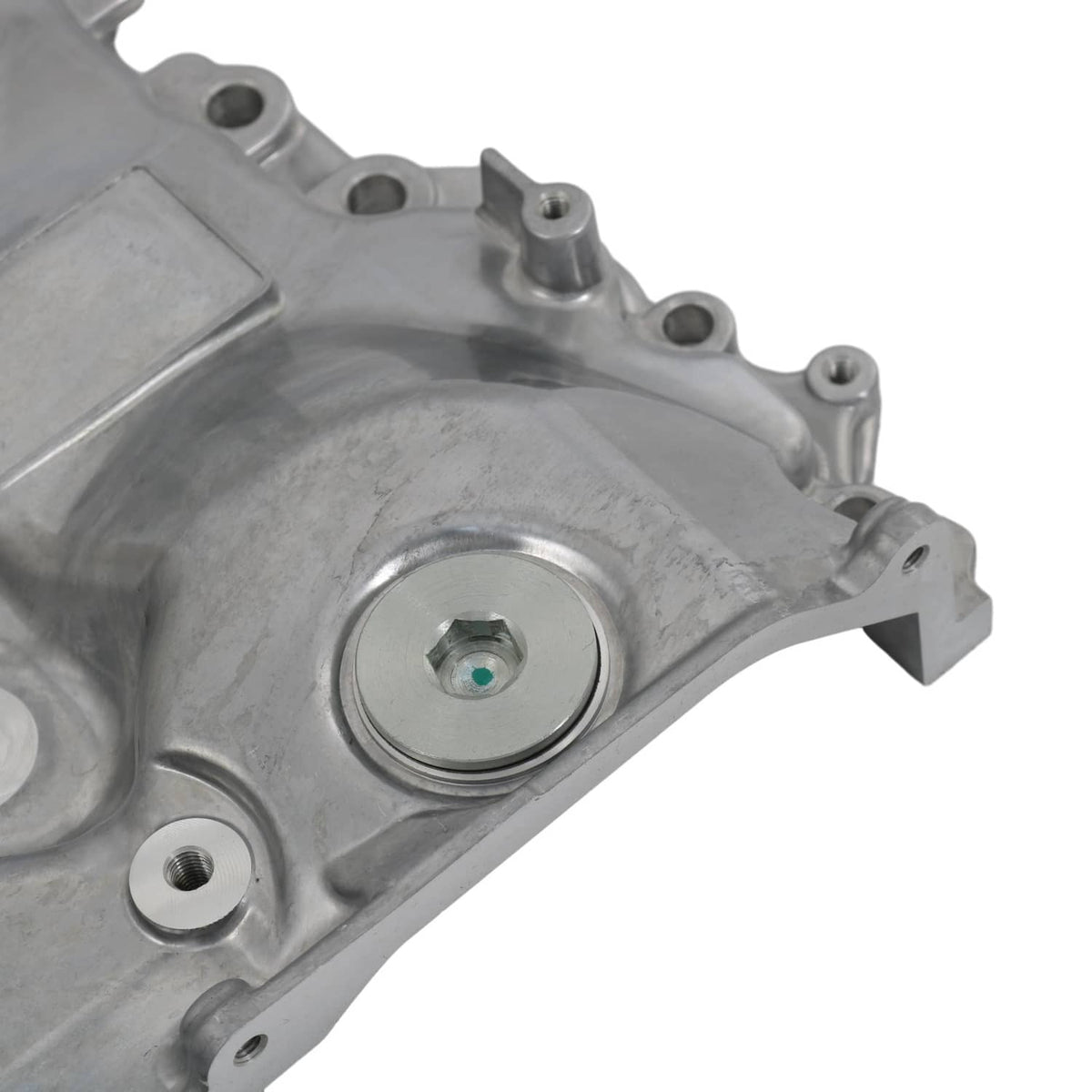 Oil pump housing close-up of round cap area with mounting holes, cast metal finish