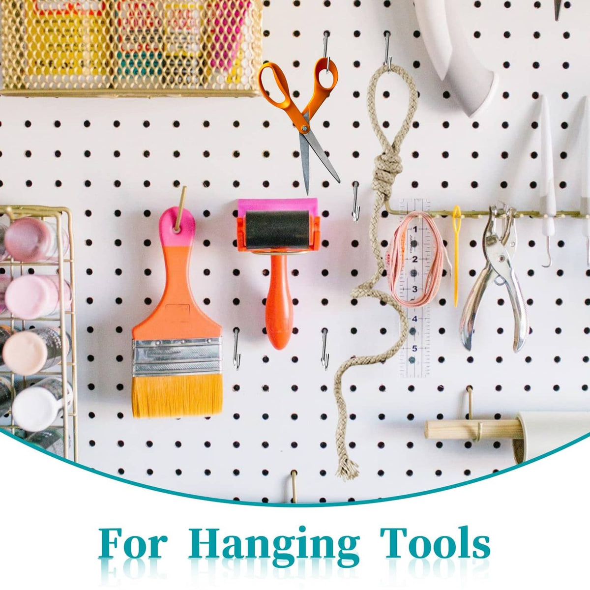 Metal S hooks on pegboard holding small tools like paint brushes