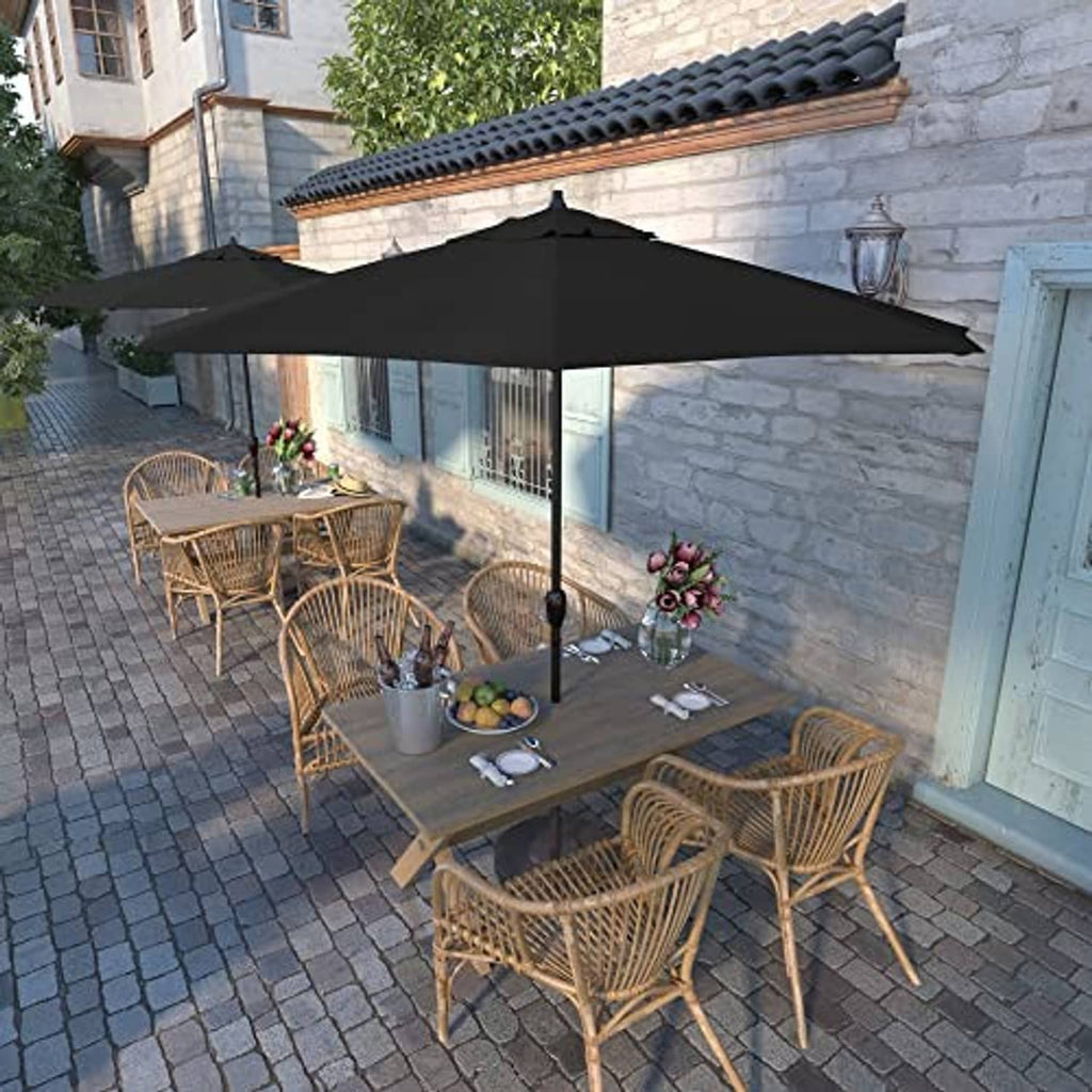 Black patio umbrella over outdoor dining set with wicker chairs and table