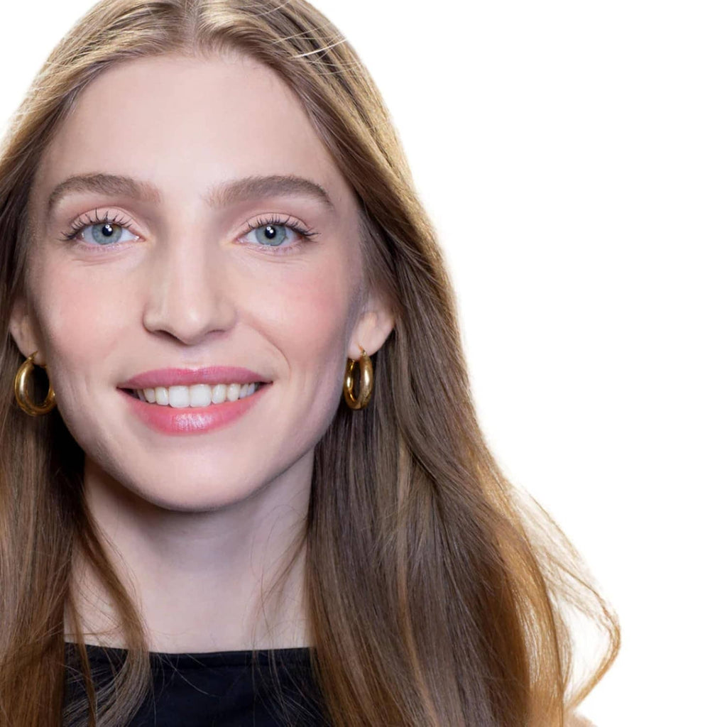 Smiling woman with rose-gold shimmer eyeshadow blended on eyelids