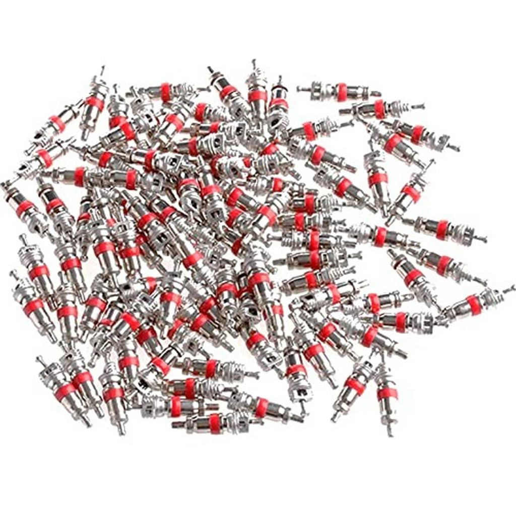 Bulk pile of tire valve stem cores, silver metal bodies with red rubber seals