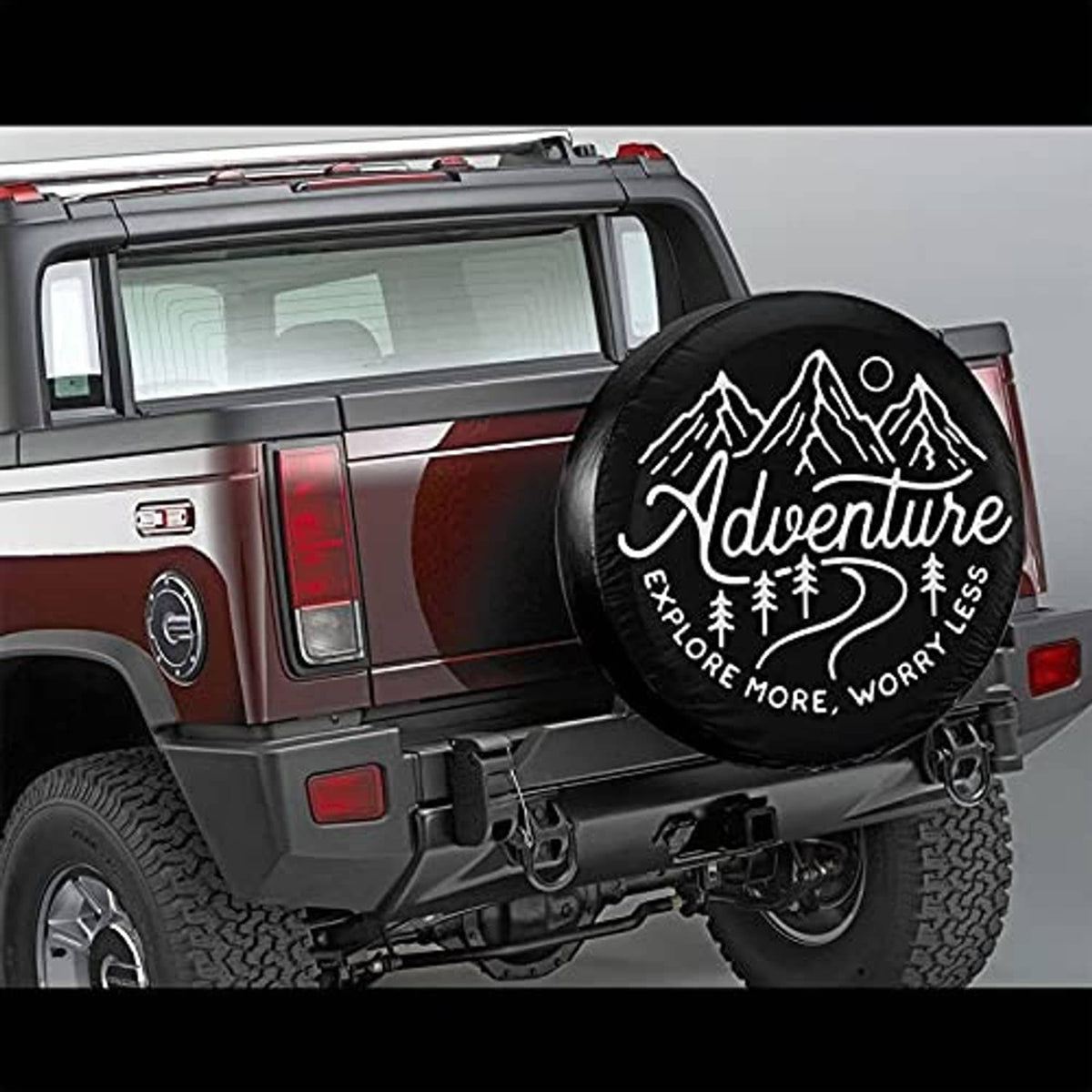 Adventure tire cover on rear of maroon RV, round black cover with logo