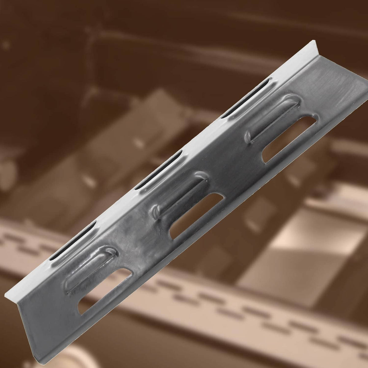 BBQ grill heat plate replacement, angled view of dark steel bar with cutout slots