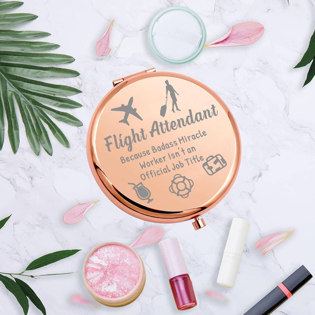 Rose-gold round makeup mirror compact with etched flight attendant theme and visible mirror.