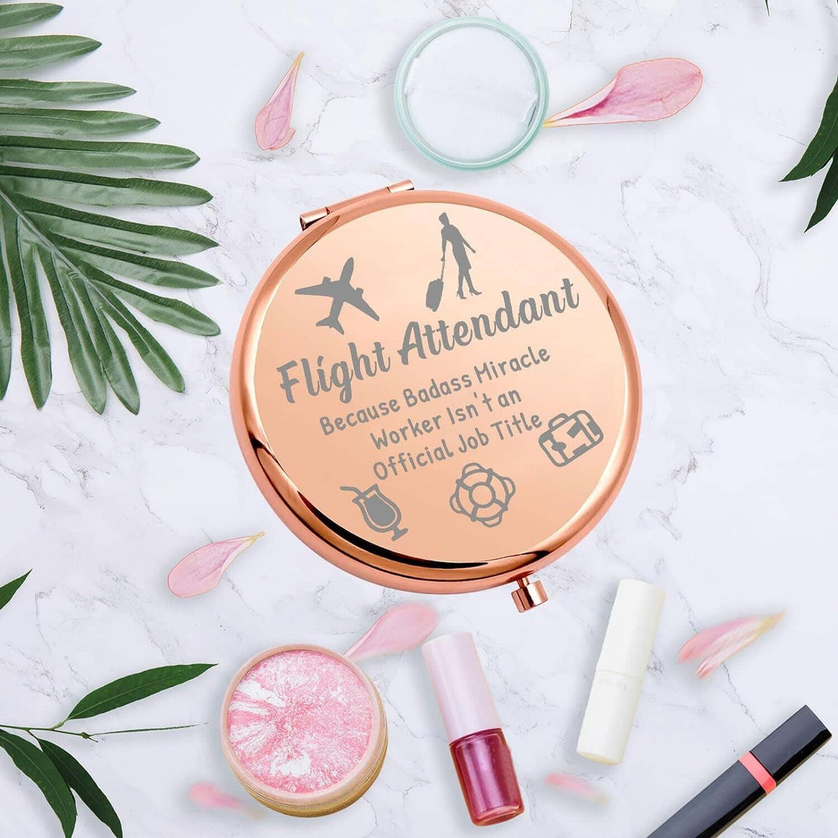 Rose-gold round makeup mirror compact with etched flight attendant theme and visible mirror.