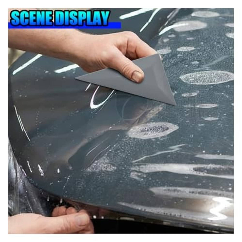 Gray triangular squeegee smoothing window tint film over wet glass