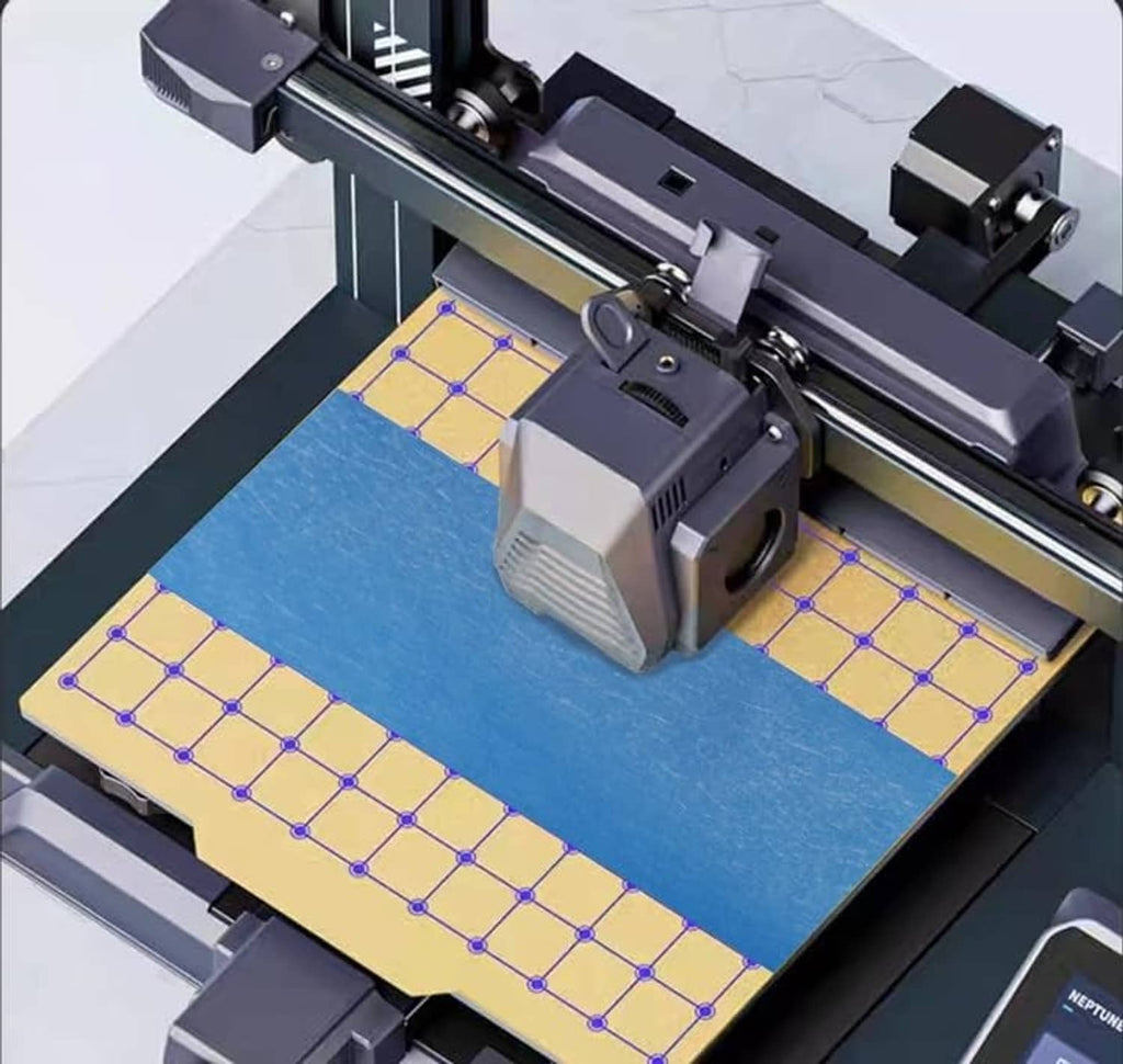Blue painter tape applied to a printer bed along the grid edges