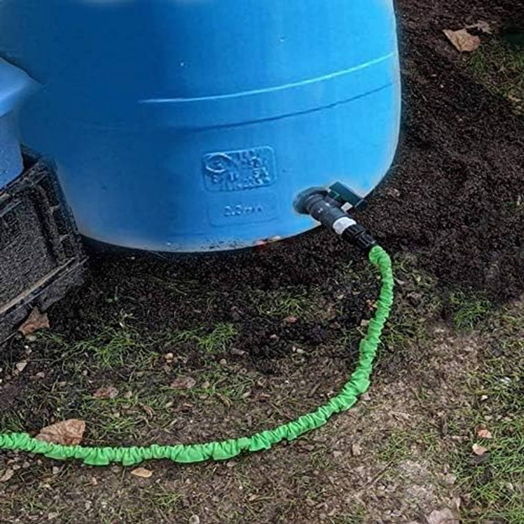 Close-up of blue rain barrel drain spigot with black fitting and green hose line
