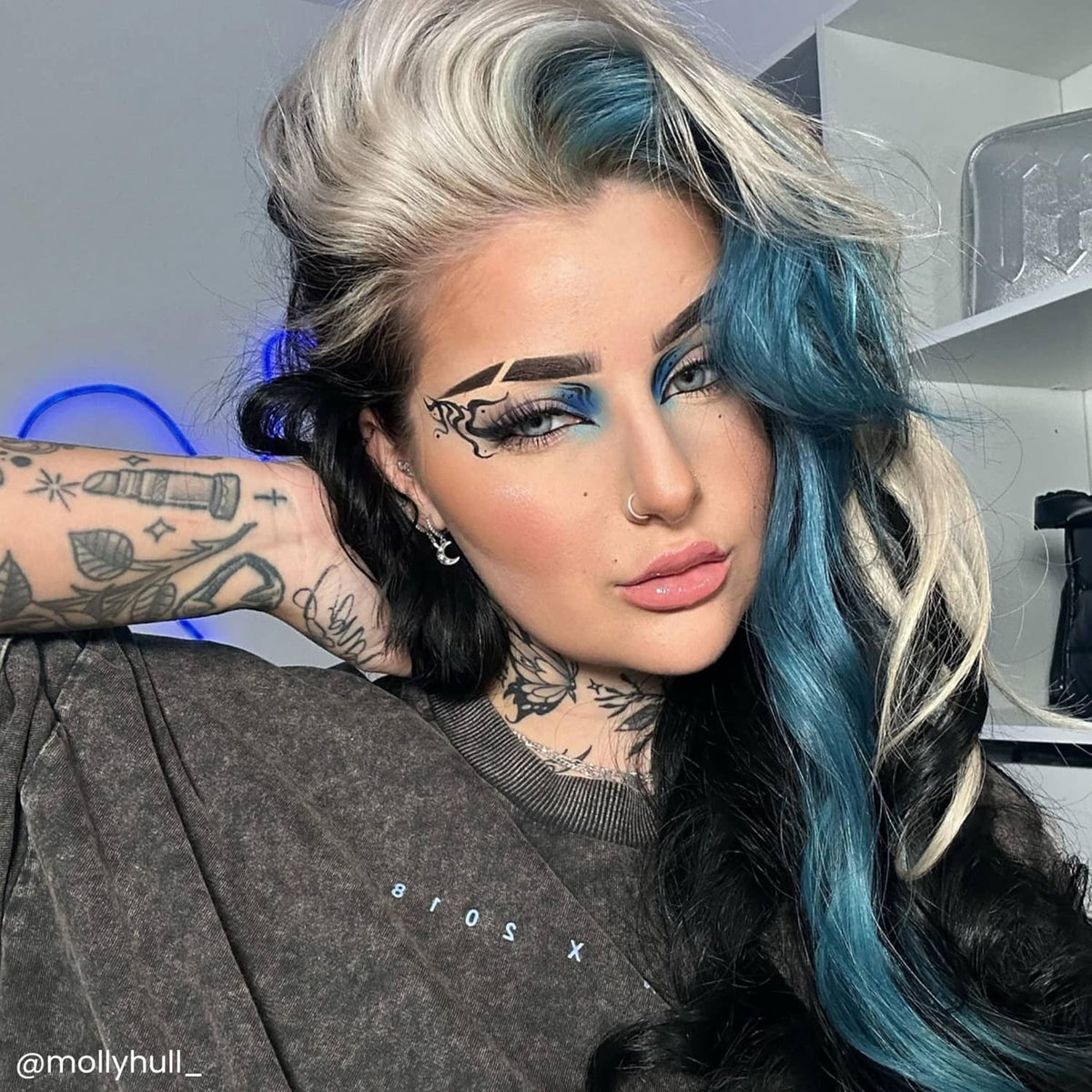 Baby blue hair dye result on wavy dark hair, shoulder-length style