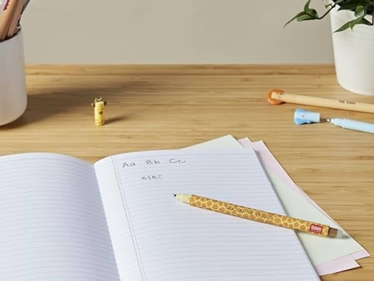 Yellow giraffe-pattern erasable gel pen writing in open notebook on wooden desk