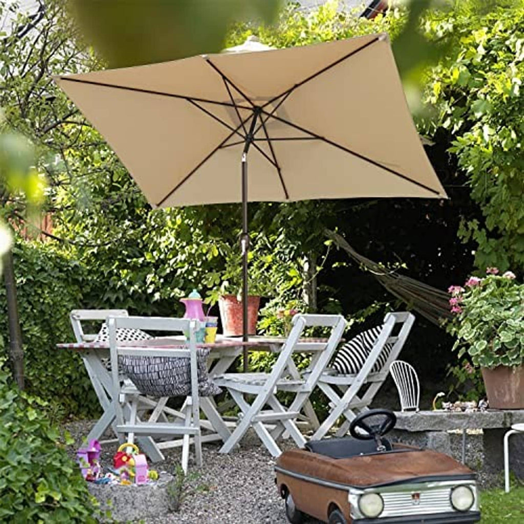 Tan rectangular patio umbrella with black ribs and center pole in outdoor seating area