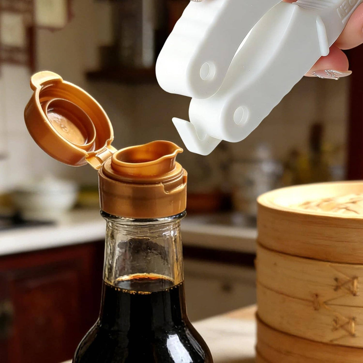 Plastic bottle cap opener gripper tool releasing a bottle cap from a dark bottle