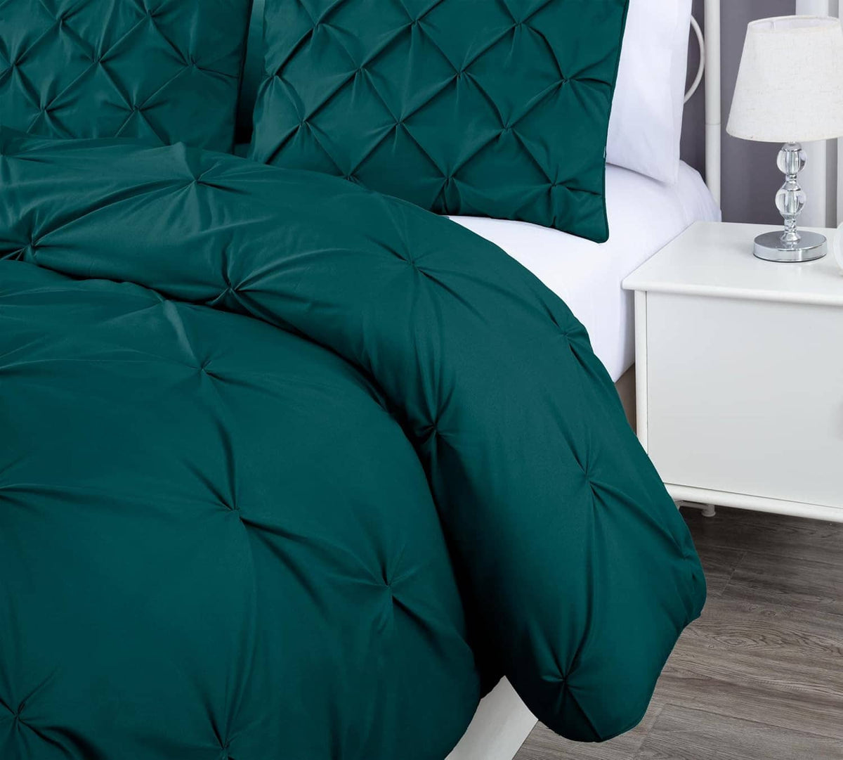 Teal diamond tufted comforter set with two shams on a white bed frame