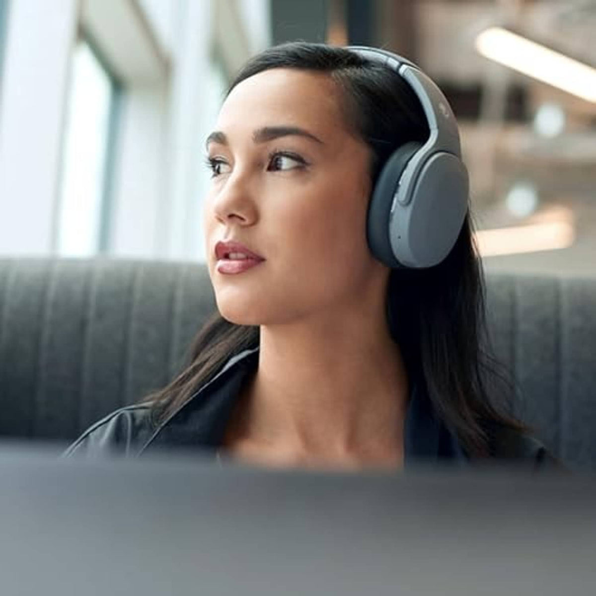 Chill grey wireless over-ear headphones worn by a person indoors