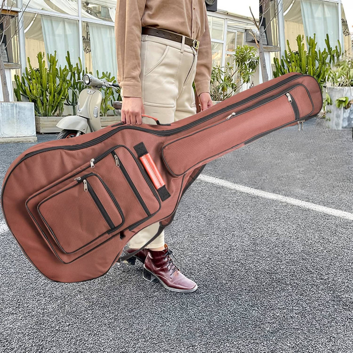 Brown padded acoustic guitar bag with multiple front zip compartments and carry straps.