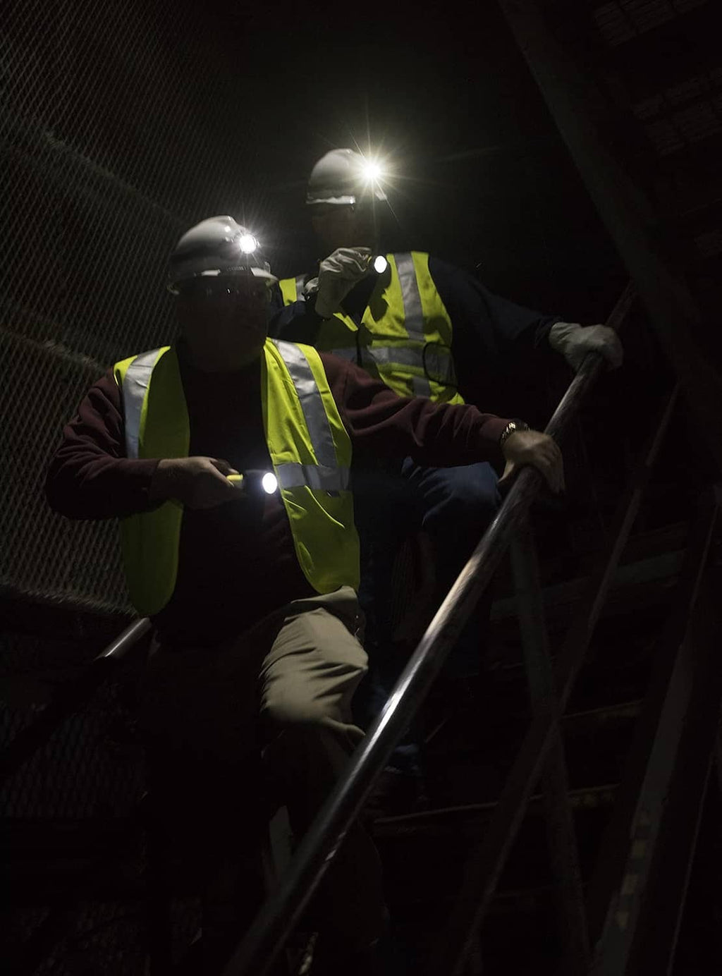Headlamp on worker’s head with bright white beam and high-visibility vest