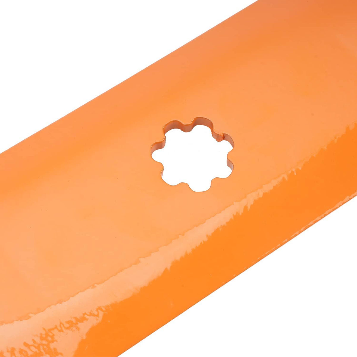 Close-up of orange mower deck blade center hole and cutting edge