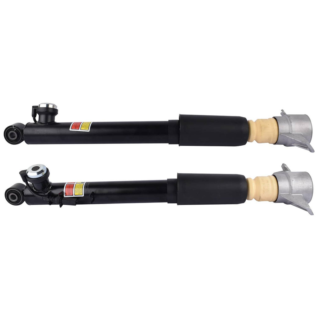 Pair of electronic shock struts with black cylindrical body, beige top bushing, gray brackets.