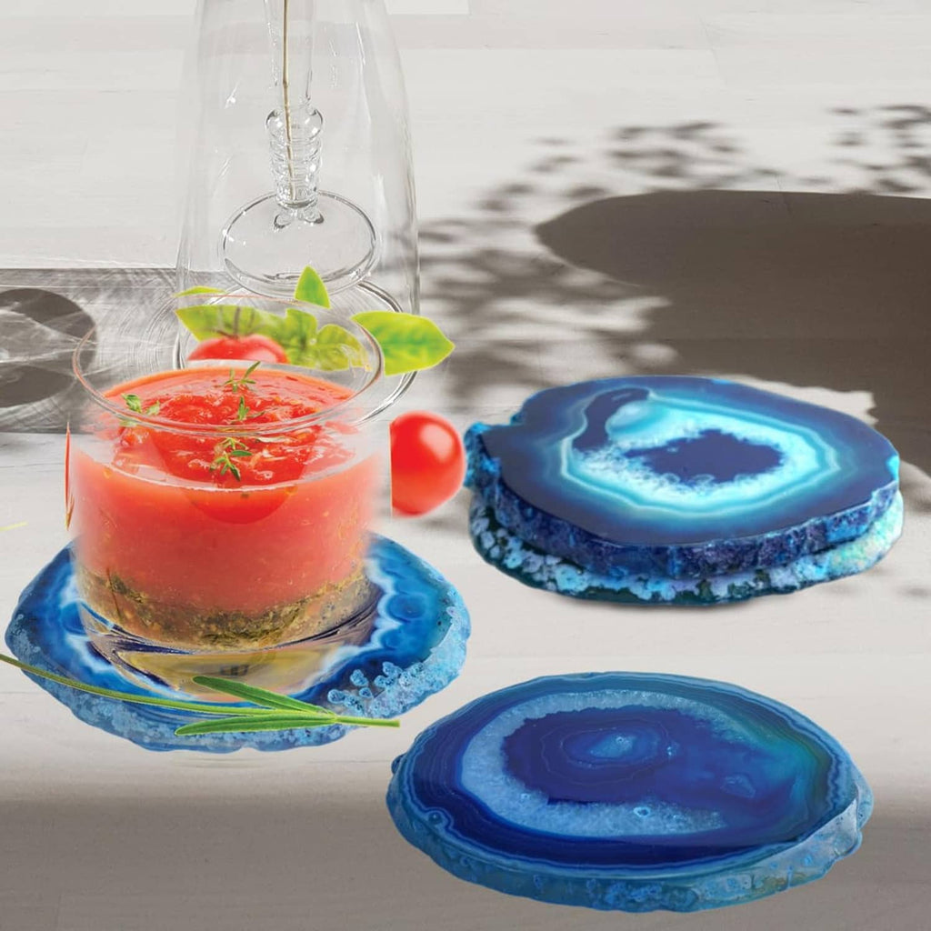 Blue agate geode coasters beneath a glass candle and other dish items