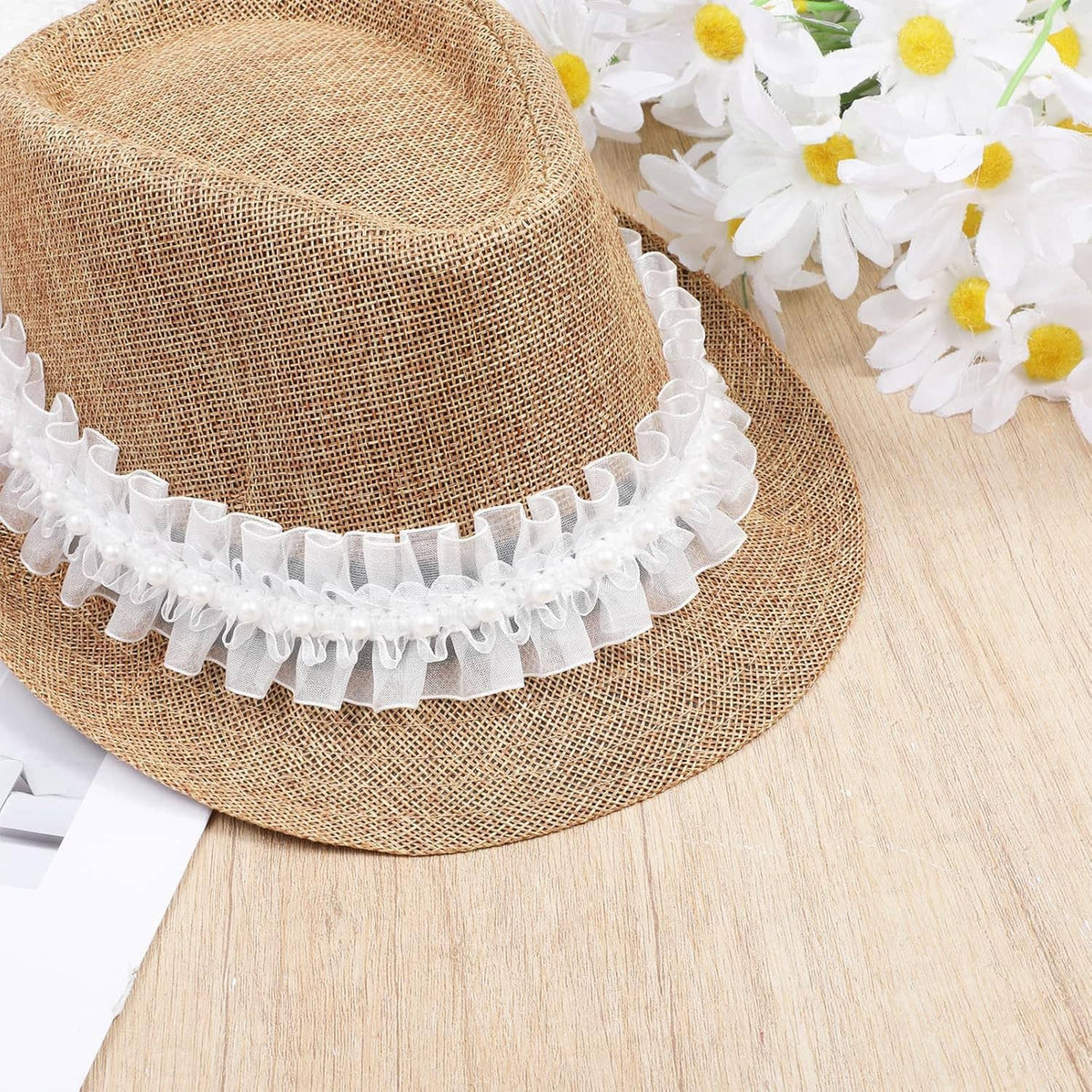 White pearl ruffle lace trim curled on a spool, with small bead embellishments