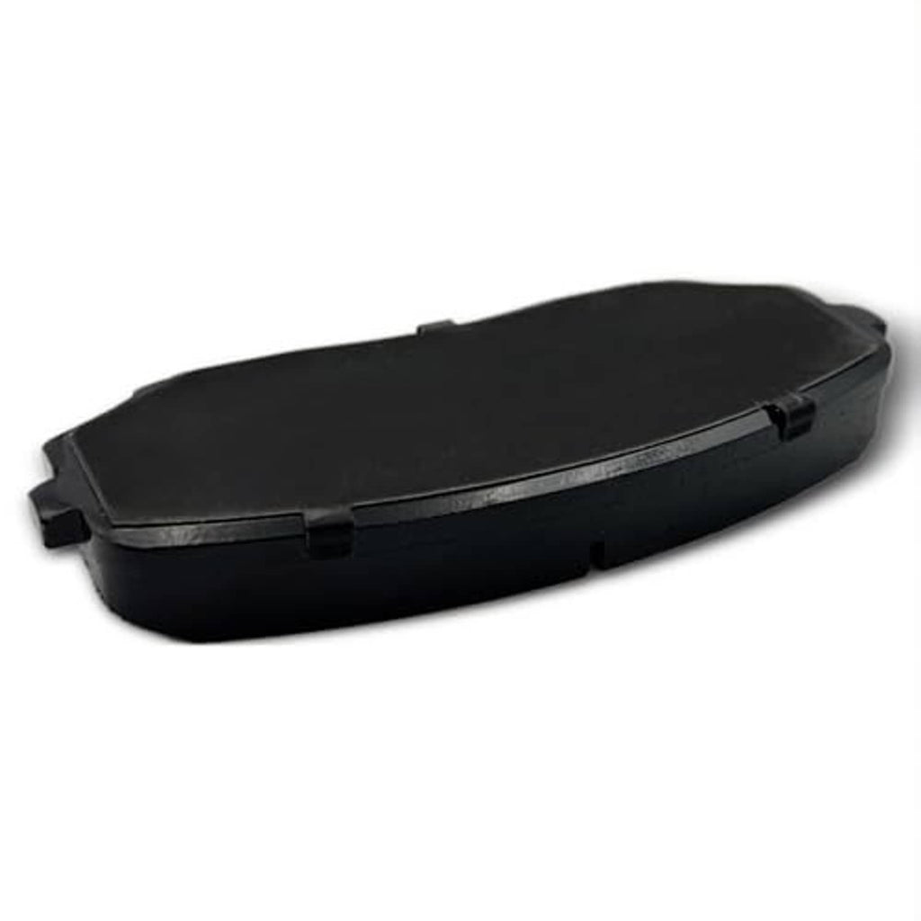 Ceramic brake pad shown from the black side with corner tabs and center seam, angled view