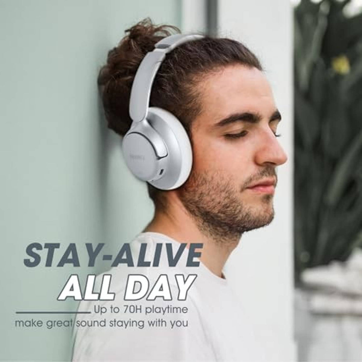 Silver over-ear wireless noise-cancelling headphones worn by a man, side view