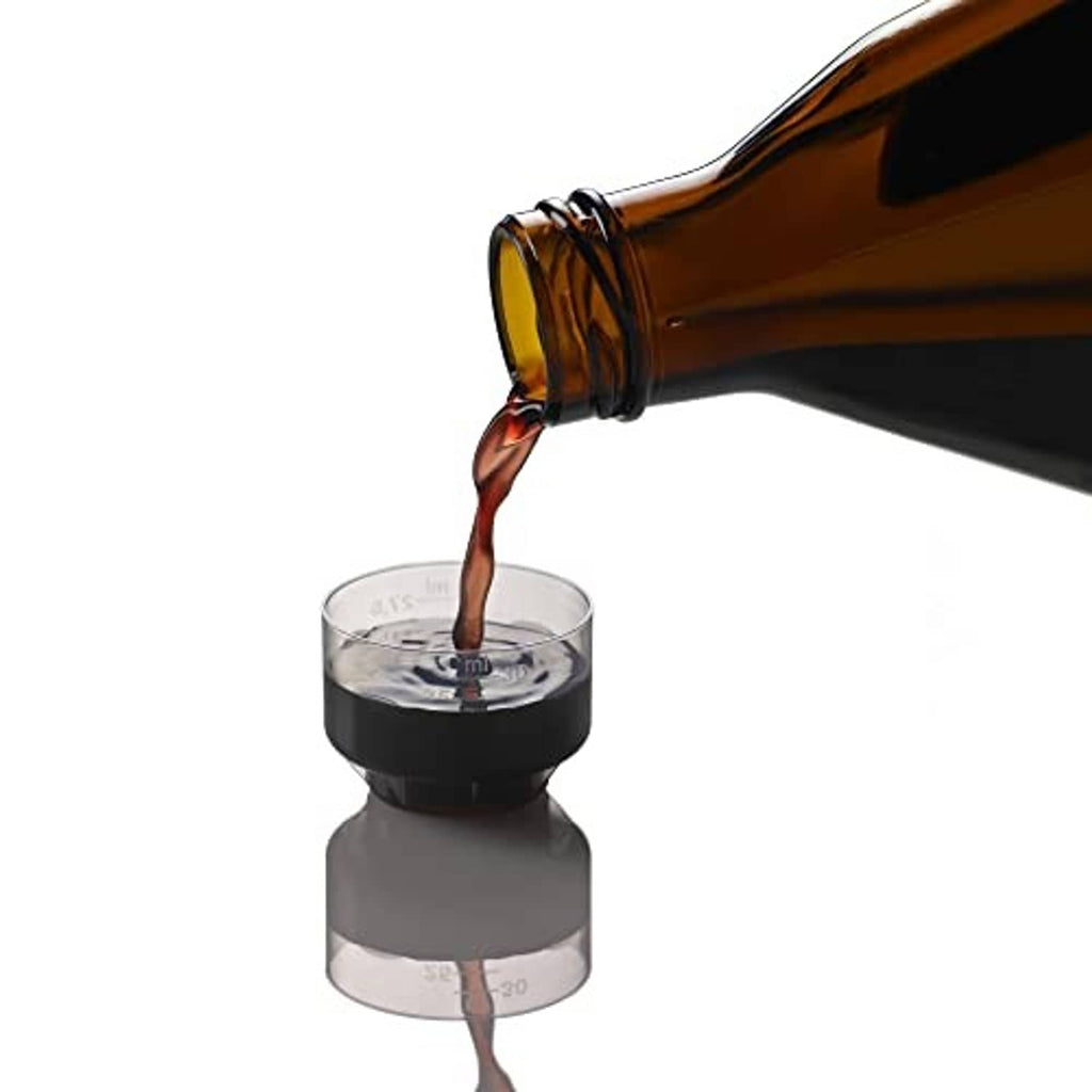 Pouring dark brown liquid iron supplement from bottle into measuring cup