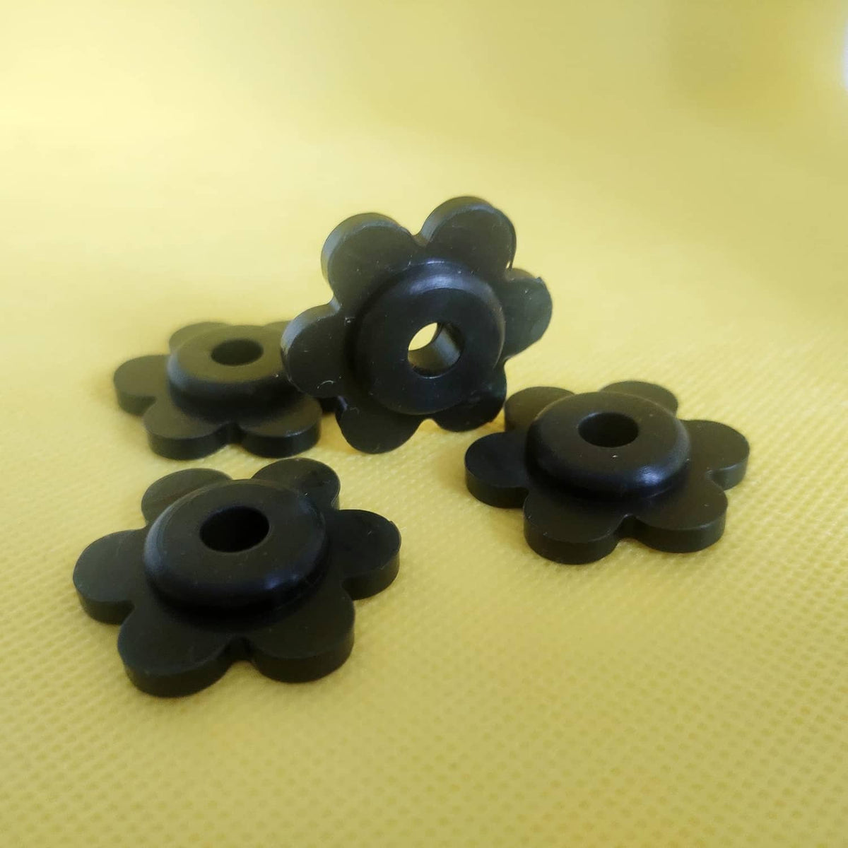Black flower-shaped rubber garden flag stoppers with center holes, set of four