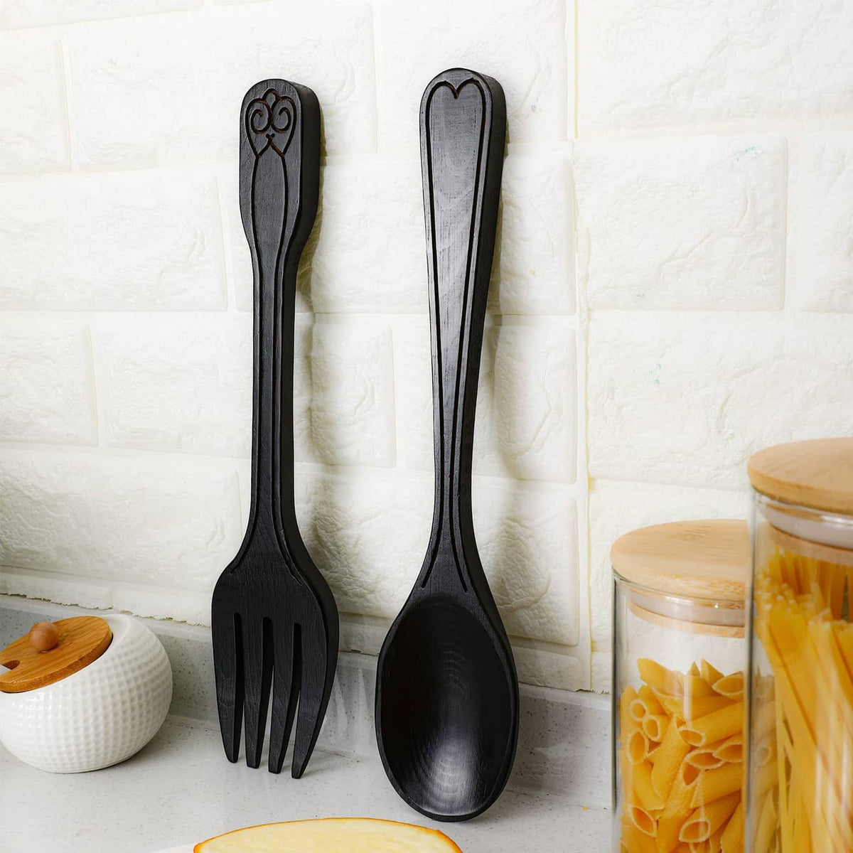 Close-up of dark metal fork and spoon wall decorations with embossed handle tips