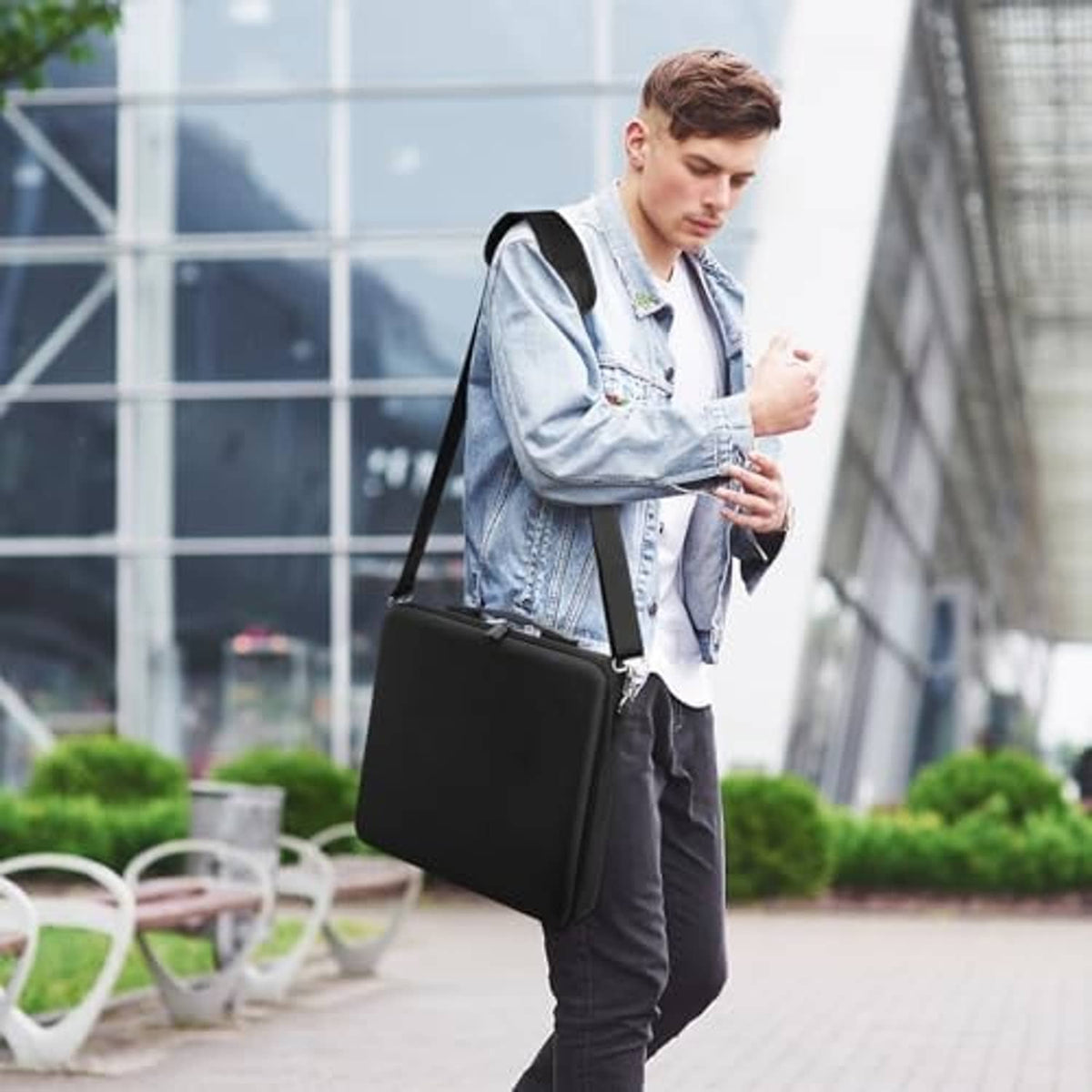 Black pool ball carrying case with handle shown on person, compact design