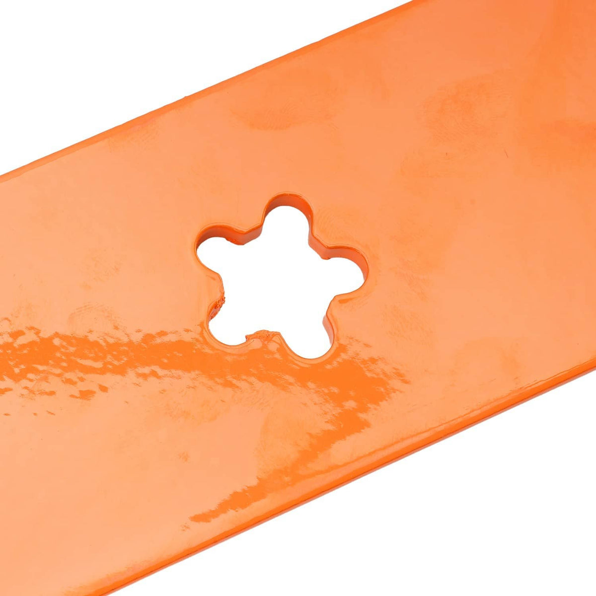 Close-up of orange mower blade with star-shaped mounting hole opening