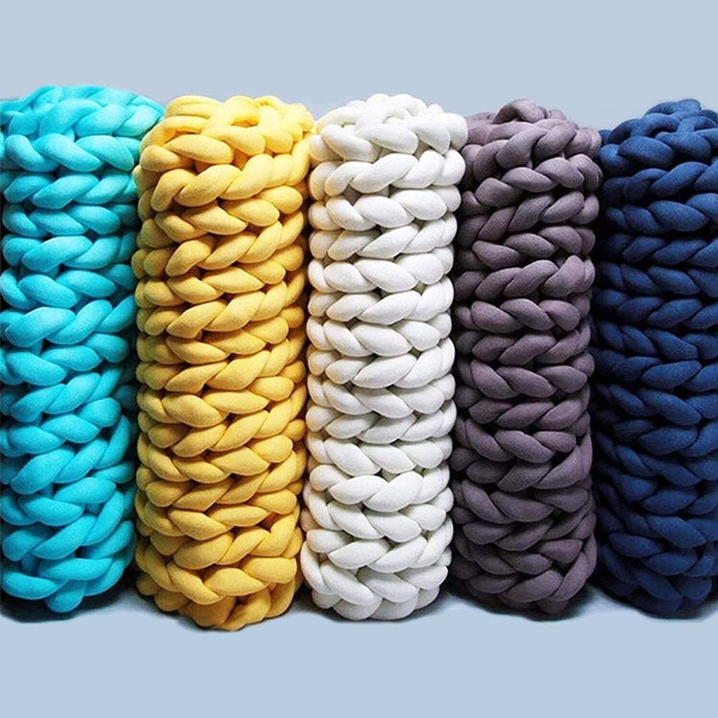 Chunky yarn rolls in turquoise, yellow, white, gray, and dark blue.
