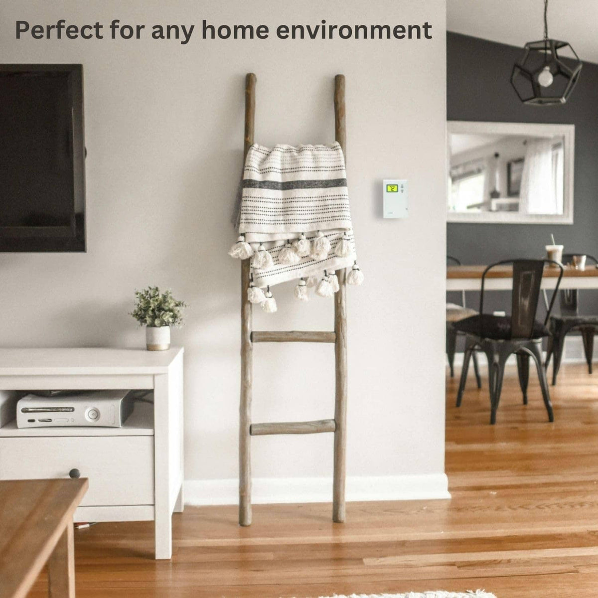 White wall-mounted thermostat with small digital display near the room baseboard
