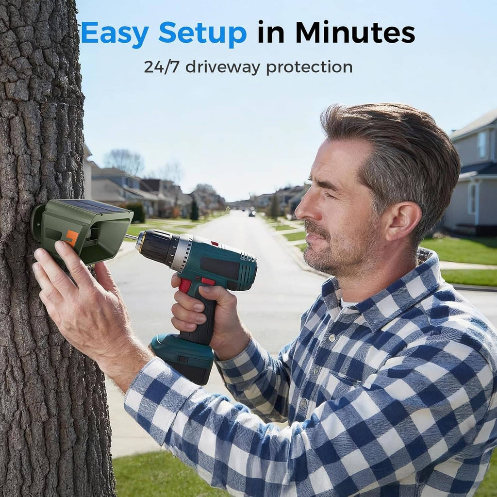 Person mounting a green radar and infrared driveway alarm sensor while holding the remote