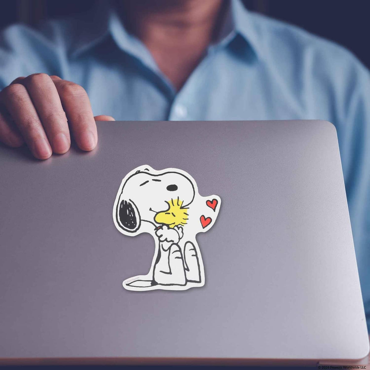 Snoopy hugging Woodstock adhesive decal on a surface, white/yellow with red hearts