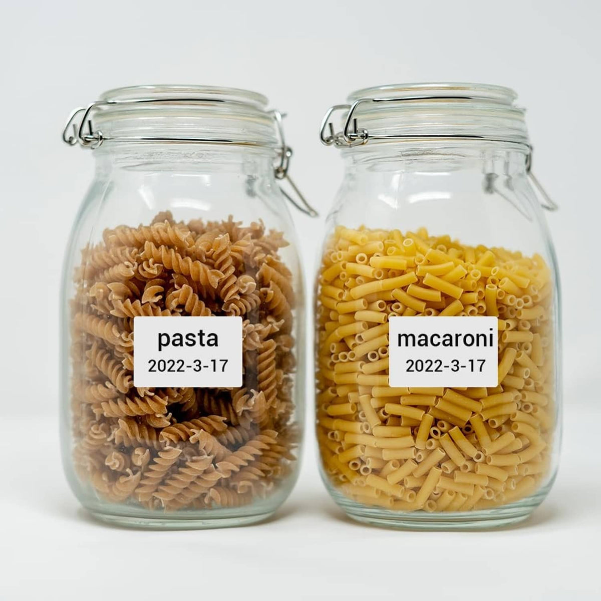 Two glass jars with label stickers reading pasta and macaroni