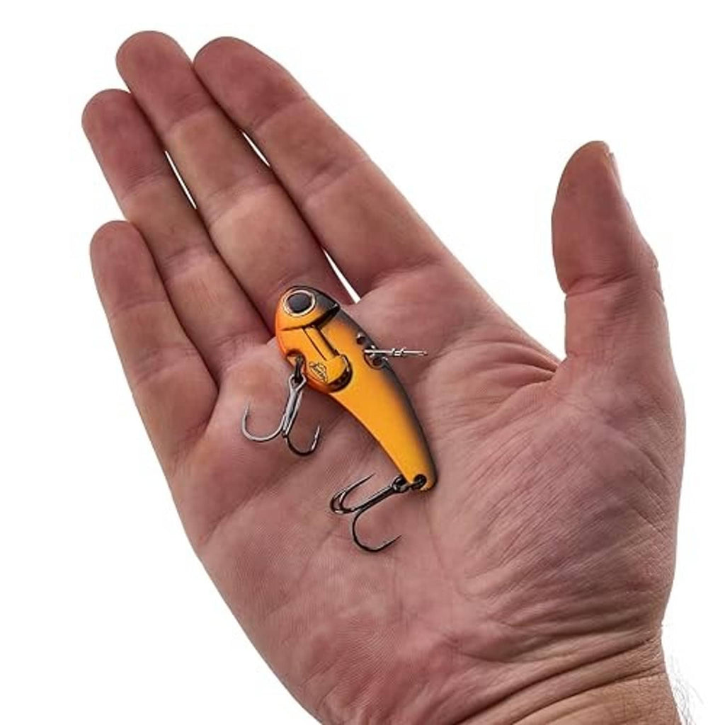 Orange and yellow sinking blade bait lure with three treble hooks held in a hand