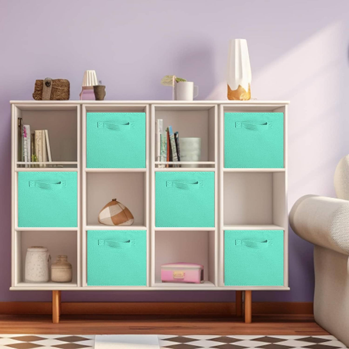 Mint green foldable fabric cubes inside a white storage cabinet with open shelves
