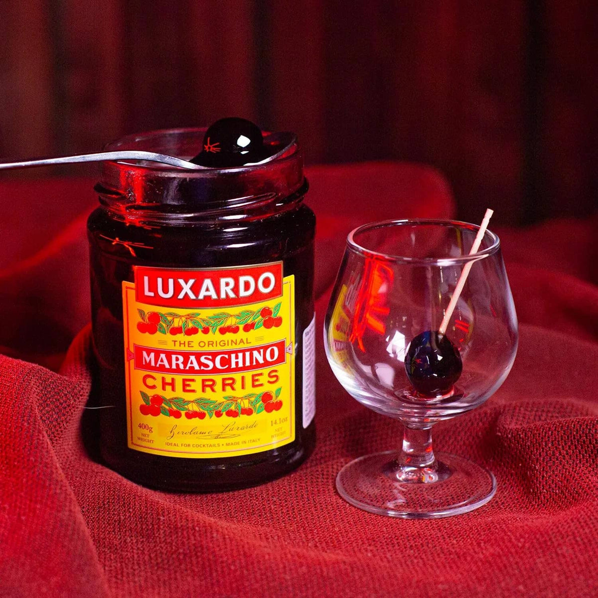 Luxardo maraschino cherries jar next to stemmed cocktail glass
