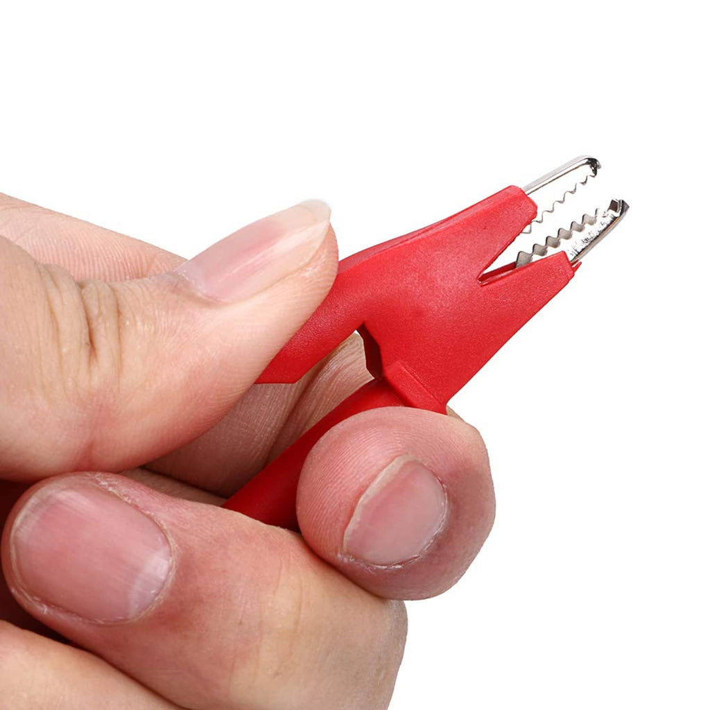 Hand holding a red and black crocodile clip with metal spring contact tips