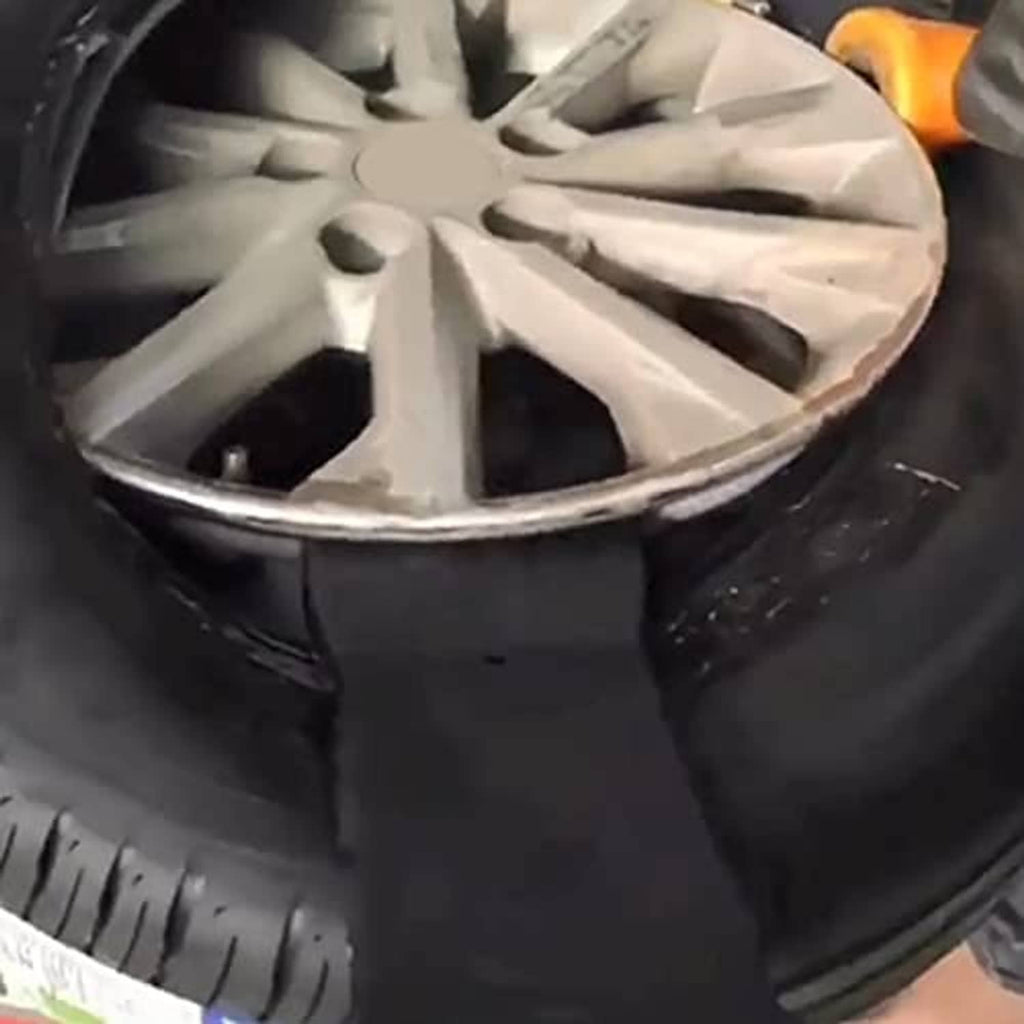 Black bead clamp gripping tire bead beside alloy wheel