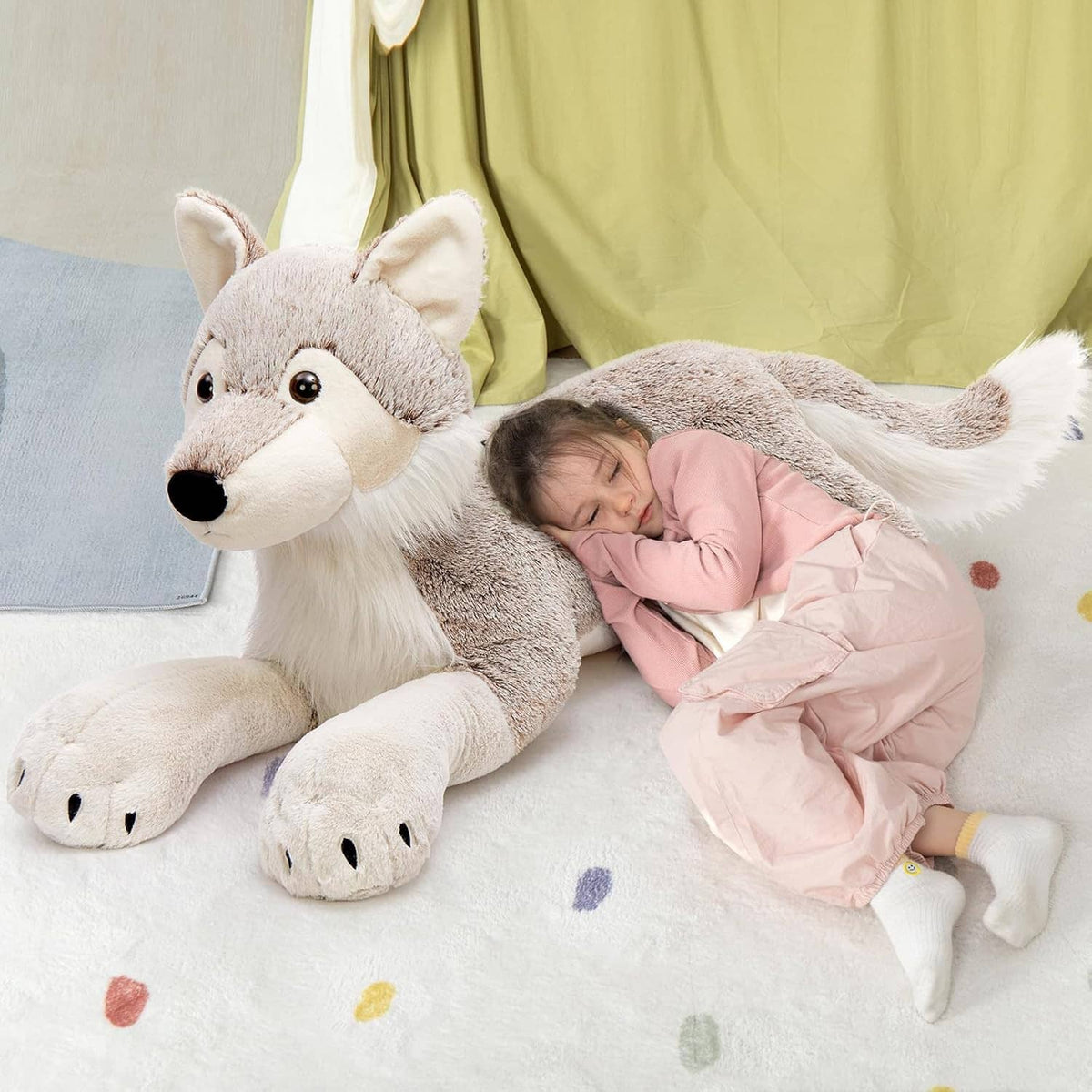 Large gray wolf plush stuffed animal with white belly and long legs, resting