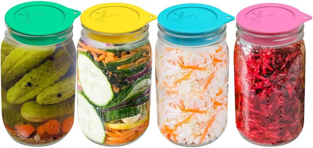 Four silicone fermenting lids for mason jars: green, yellow, blue, and pink airlock tops.