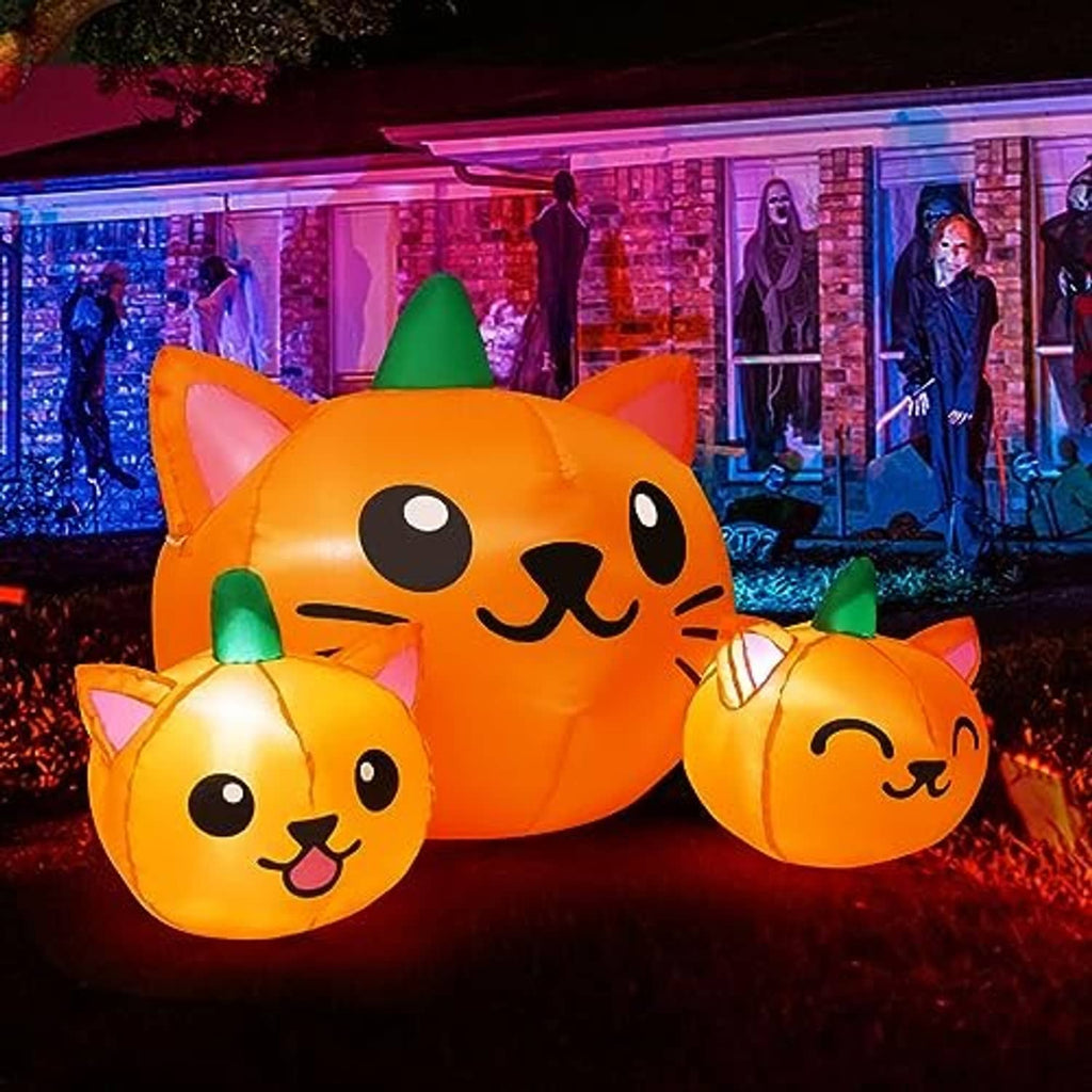 Orange inflatable cat-head trio with green cone hats, glowing Halloween yard decor