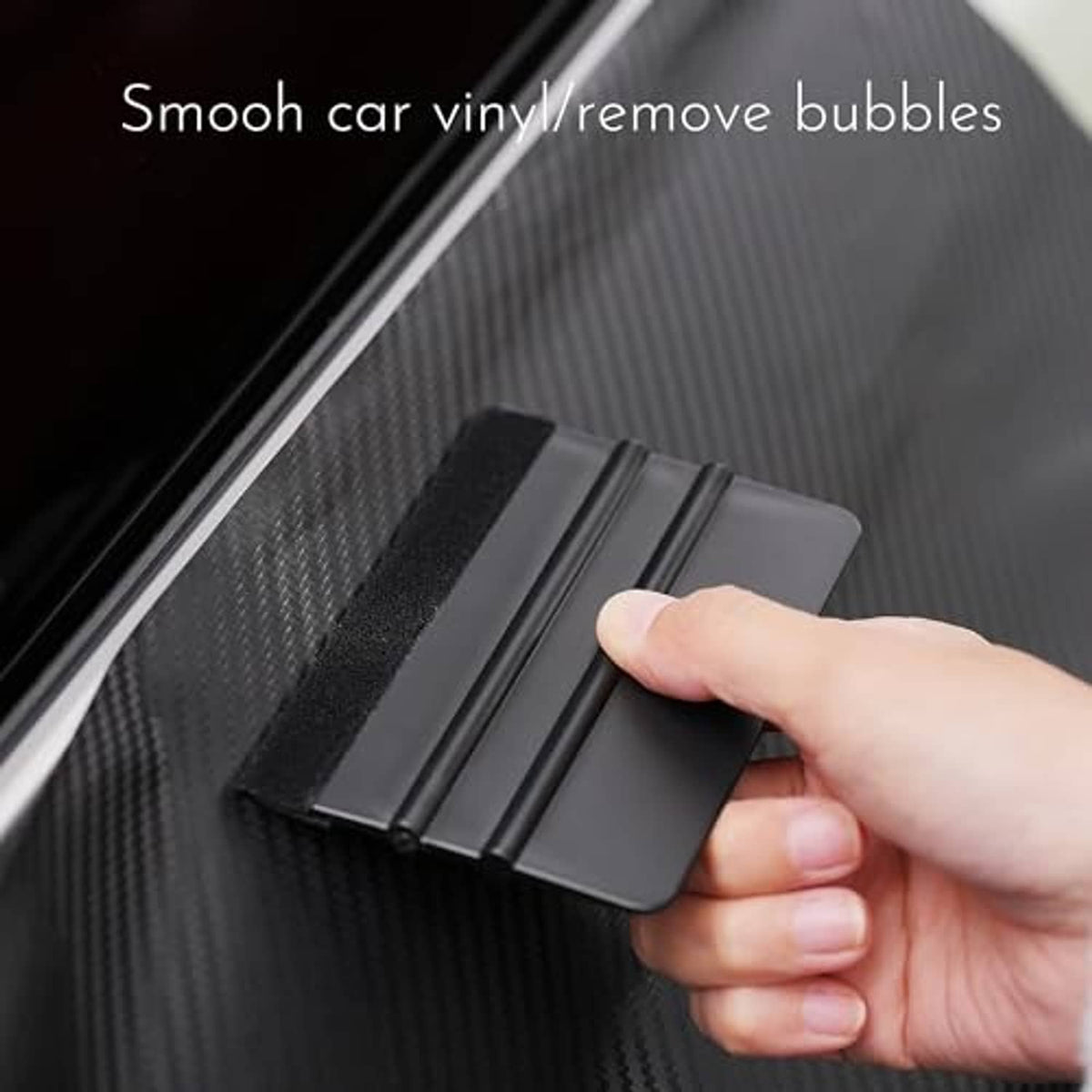 Felt edge squeegee smoothing car window vinyl to remove bubbles.
