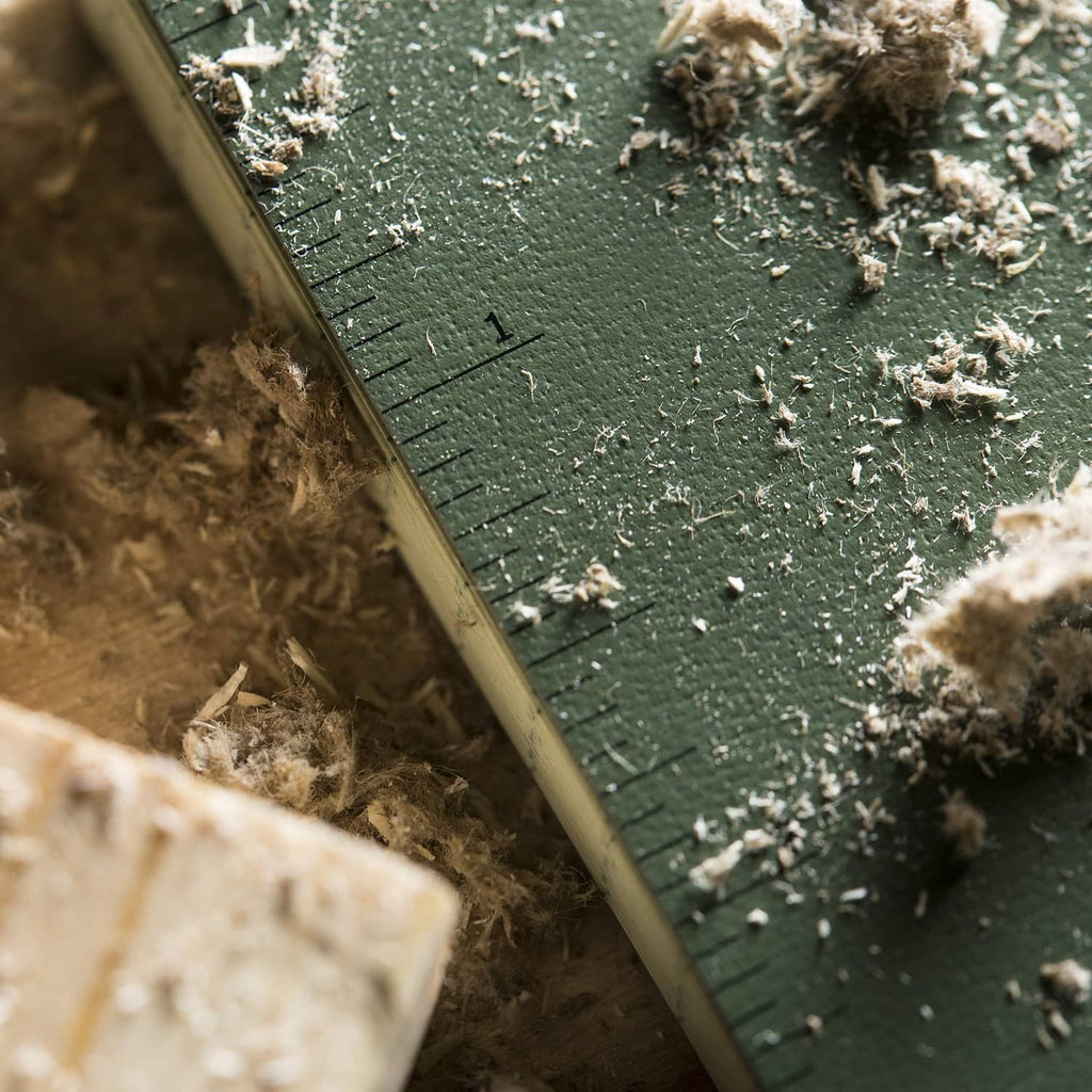 Weatherproof notebook page corner with ruler-style lines, dust and debris on cover surface