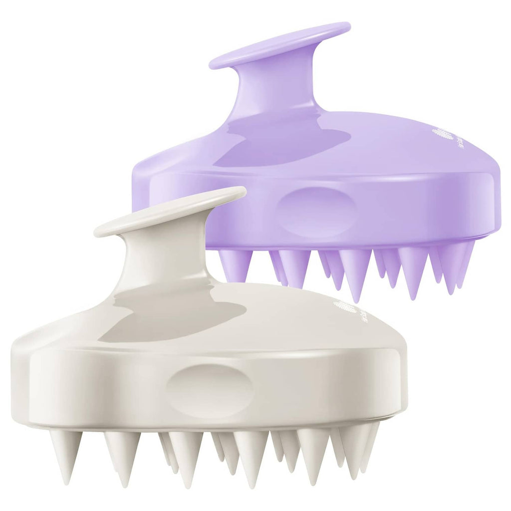 Two scalp massager scrub brushes, purple and light beige, with flexible bristle tips.