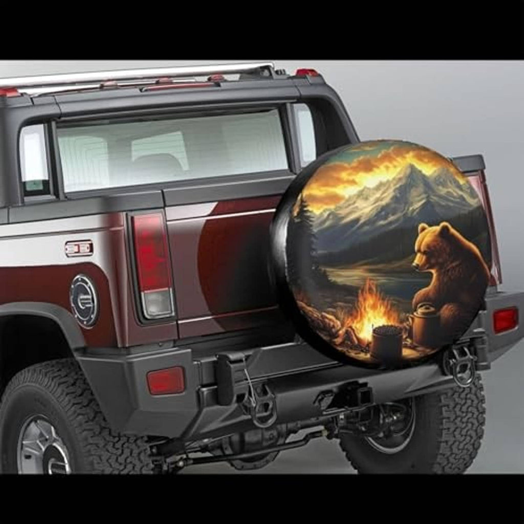 Spare tire cover on SUV rear with bear, mountains, and fire pit artwork